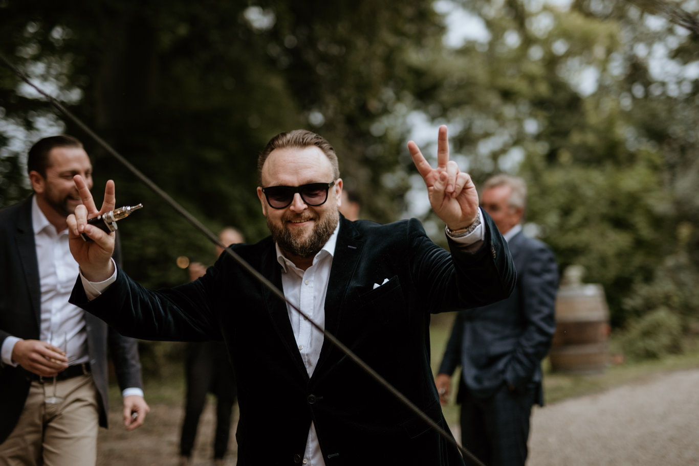 Mann macht lachend Peace-Zeichen bei der Feier