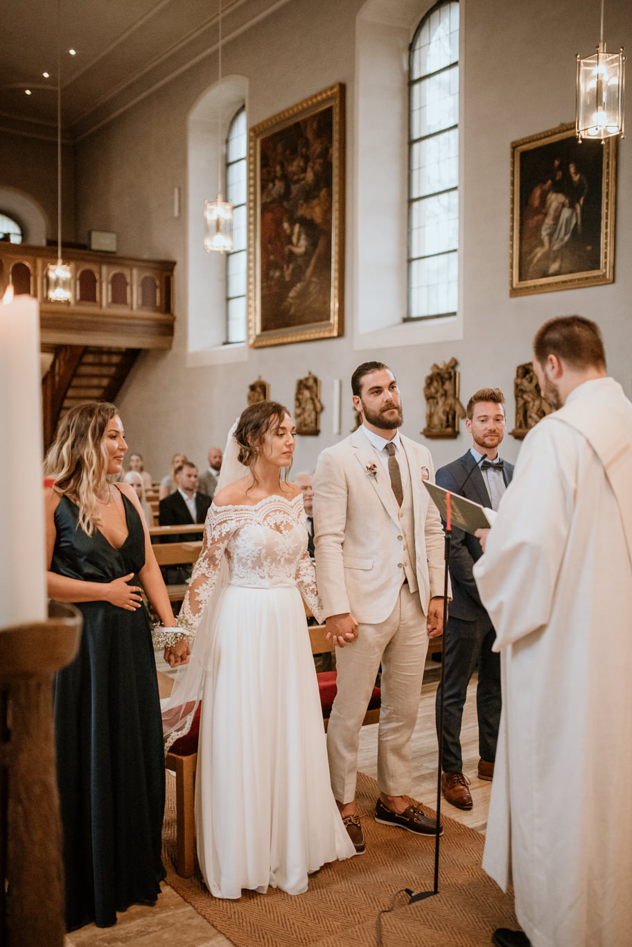 Brautpaar steht lächelnd vor dem Traualtar in der Kirche