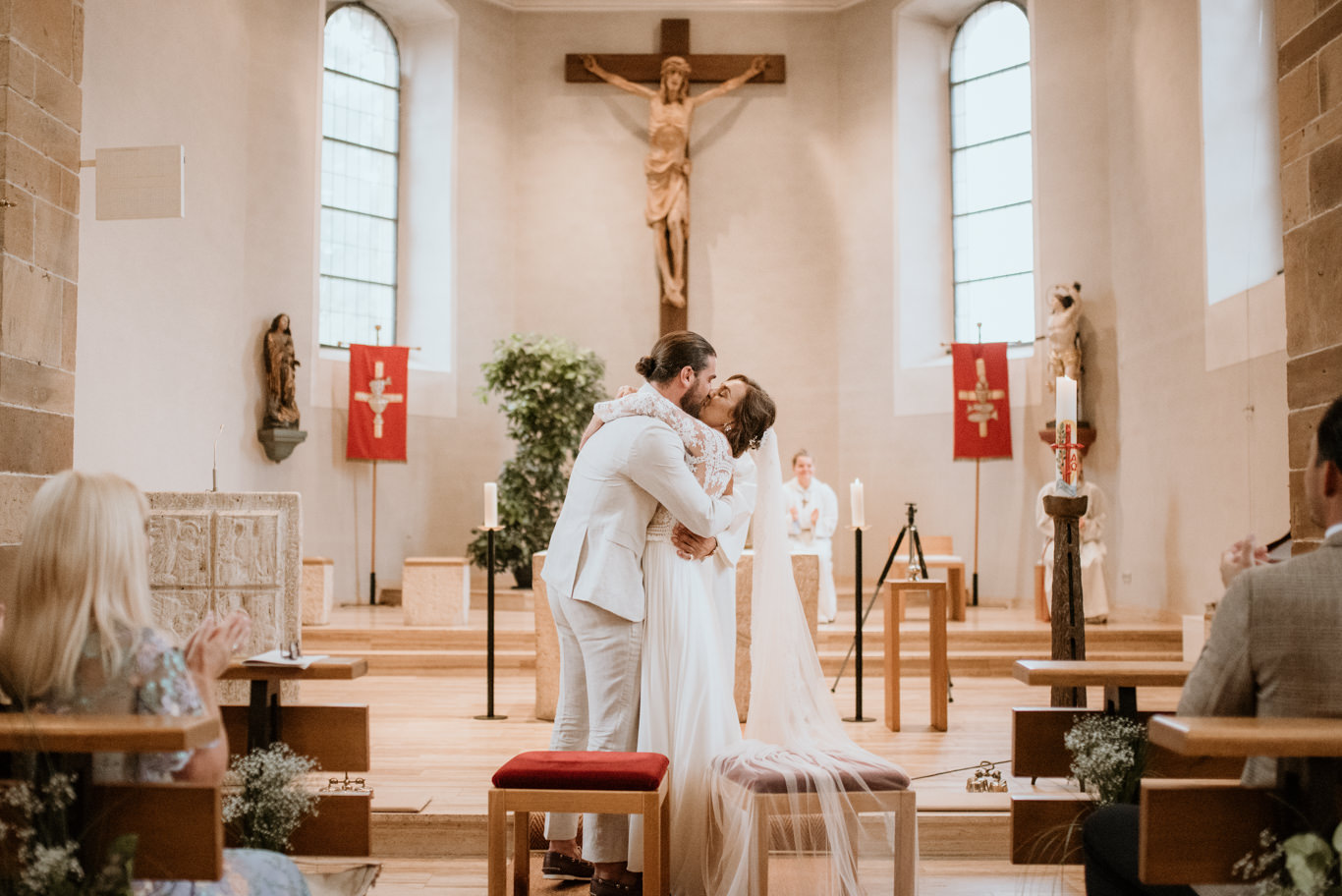 Brautpaar steht am Altar vor einem Kruzifix