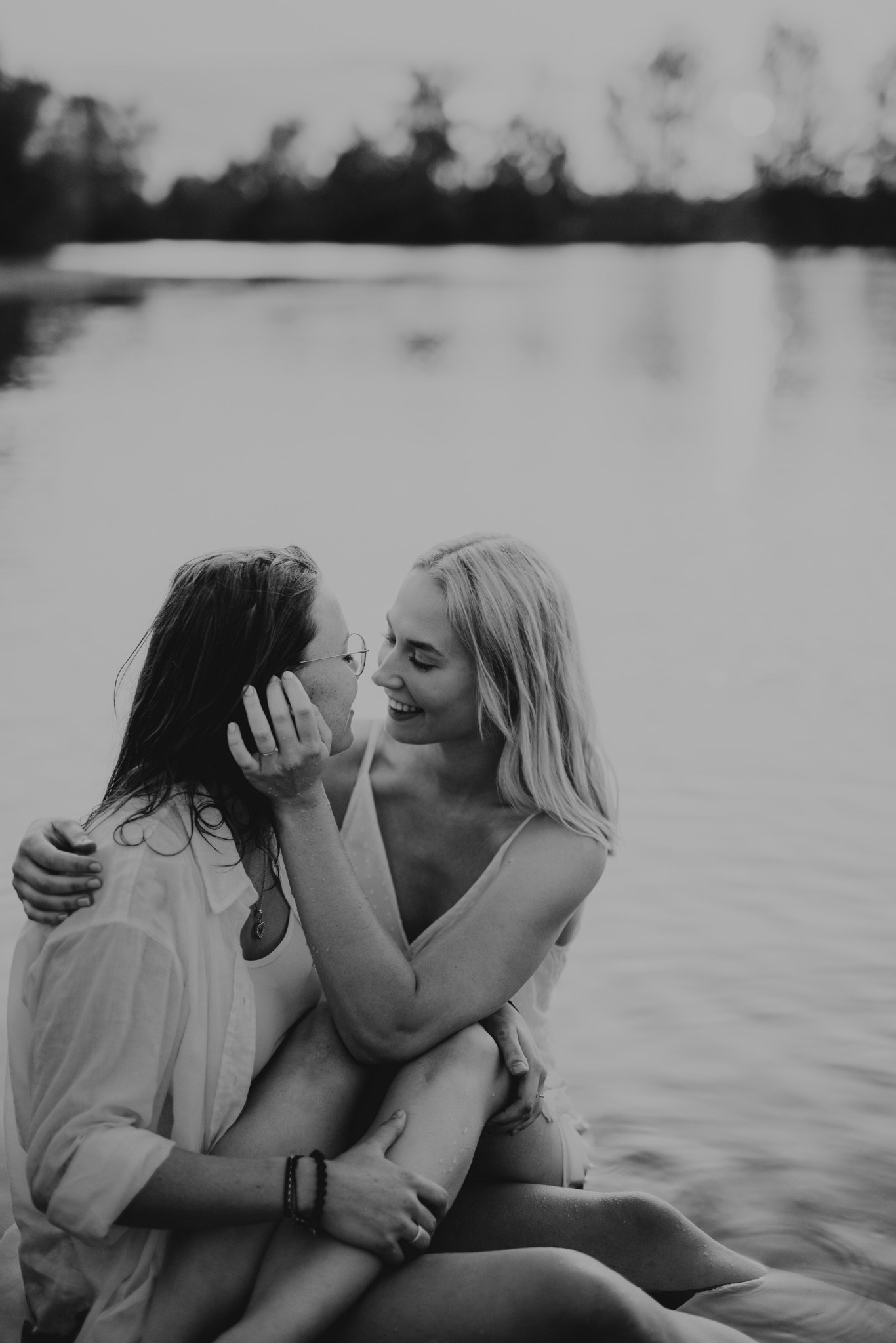 Schwarzweißaufnahme zweier Frauen, die sich im Wasser umarmen