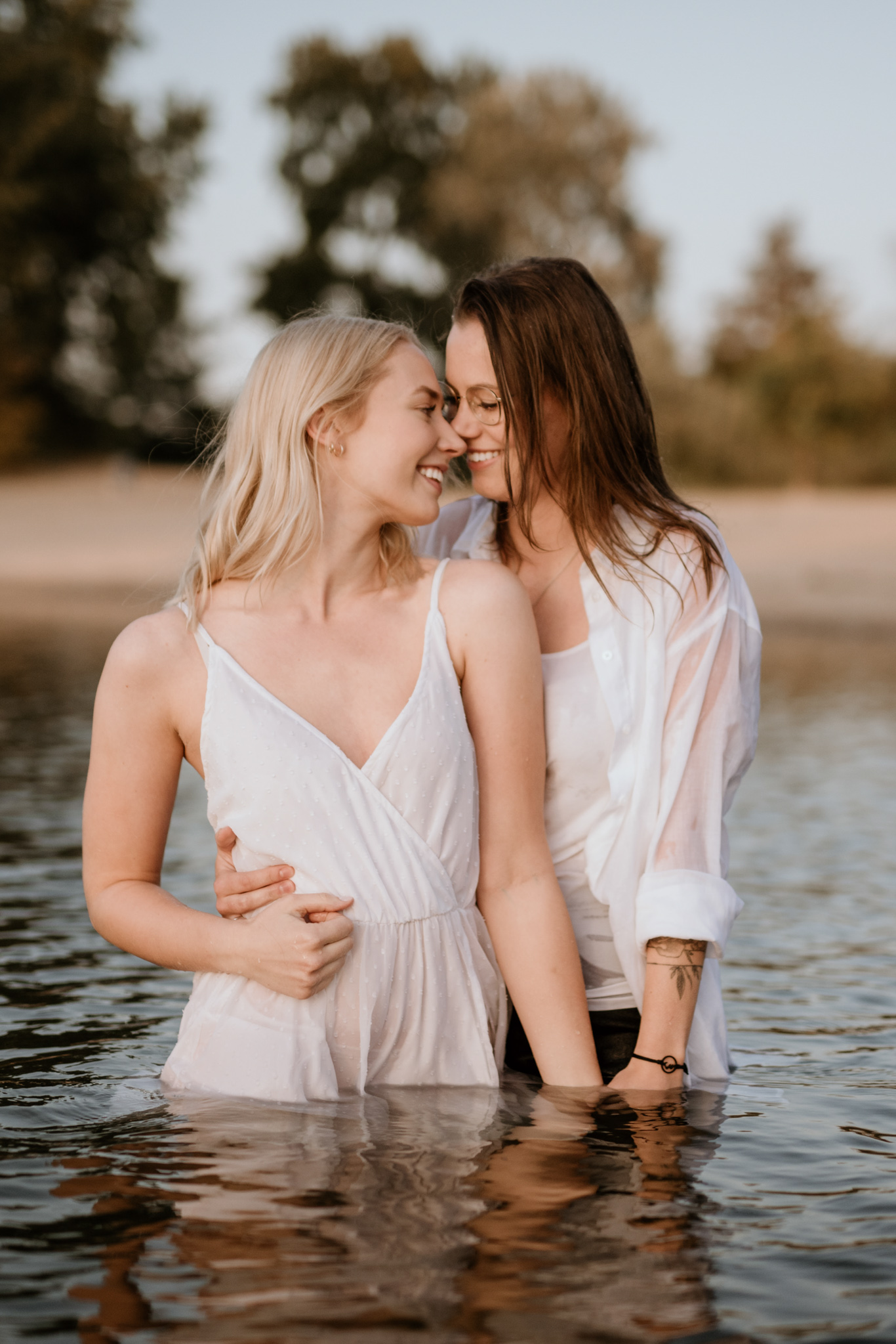 Zwei Frauen stehen Stirn an Stirn im knietiefen Wasser