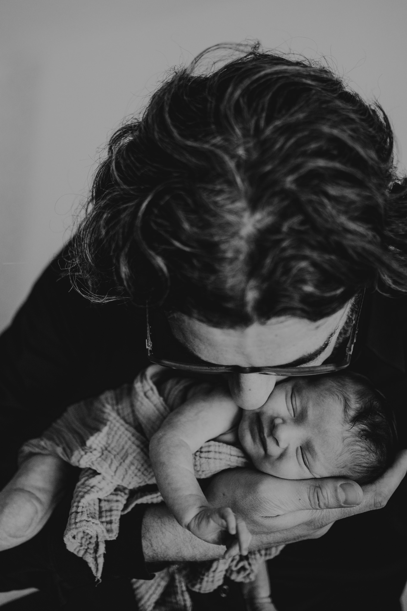 Vater drückt sein weinendes Baby zärtlich an sich, Schwarzweißaufnahme
