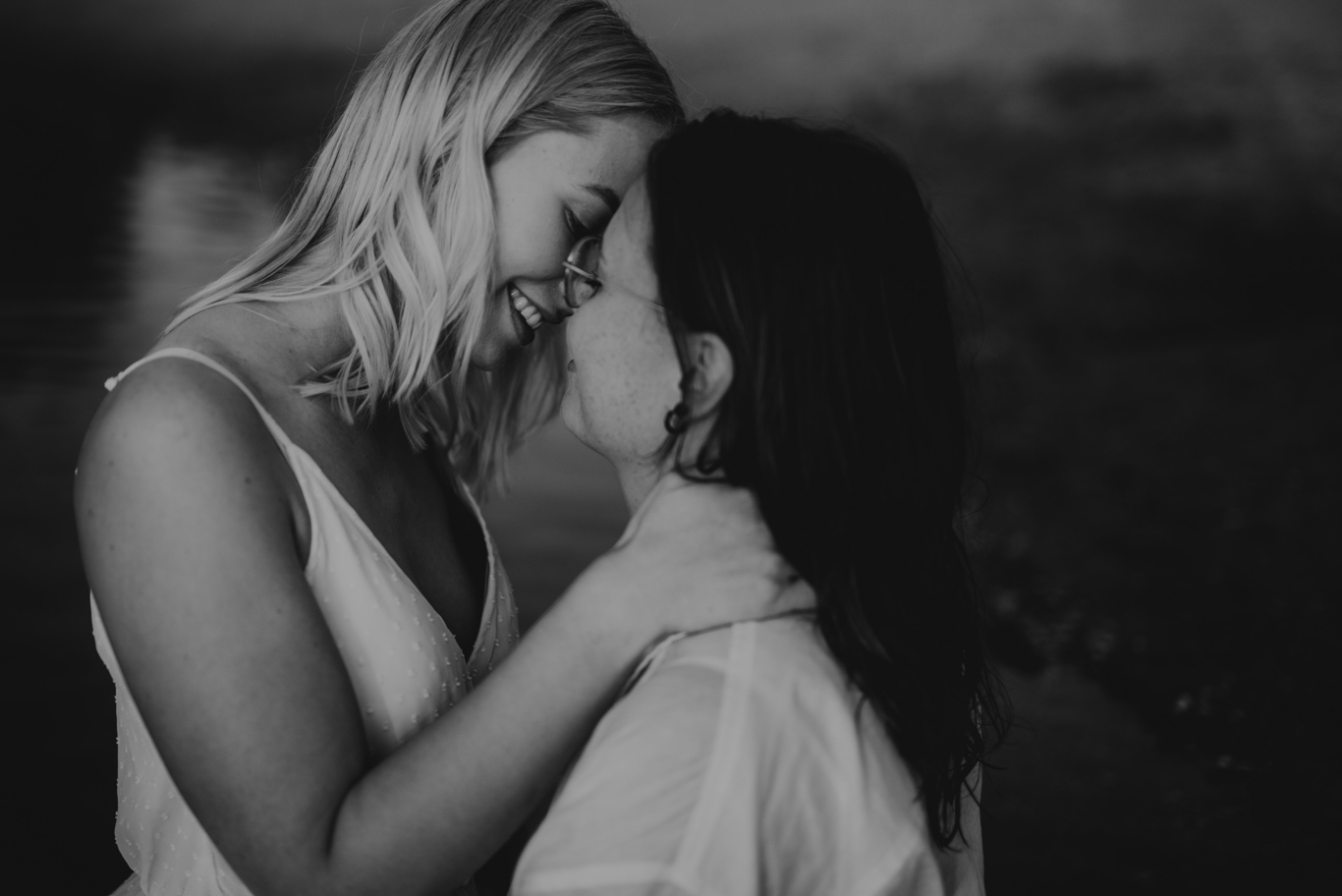Zwei Frauen lachen eng umschlungen beieinander, Schwarzweißaufnahme