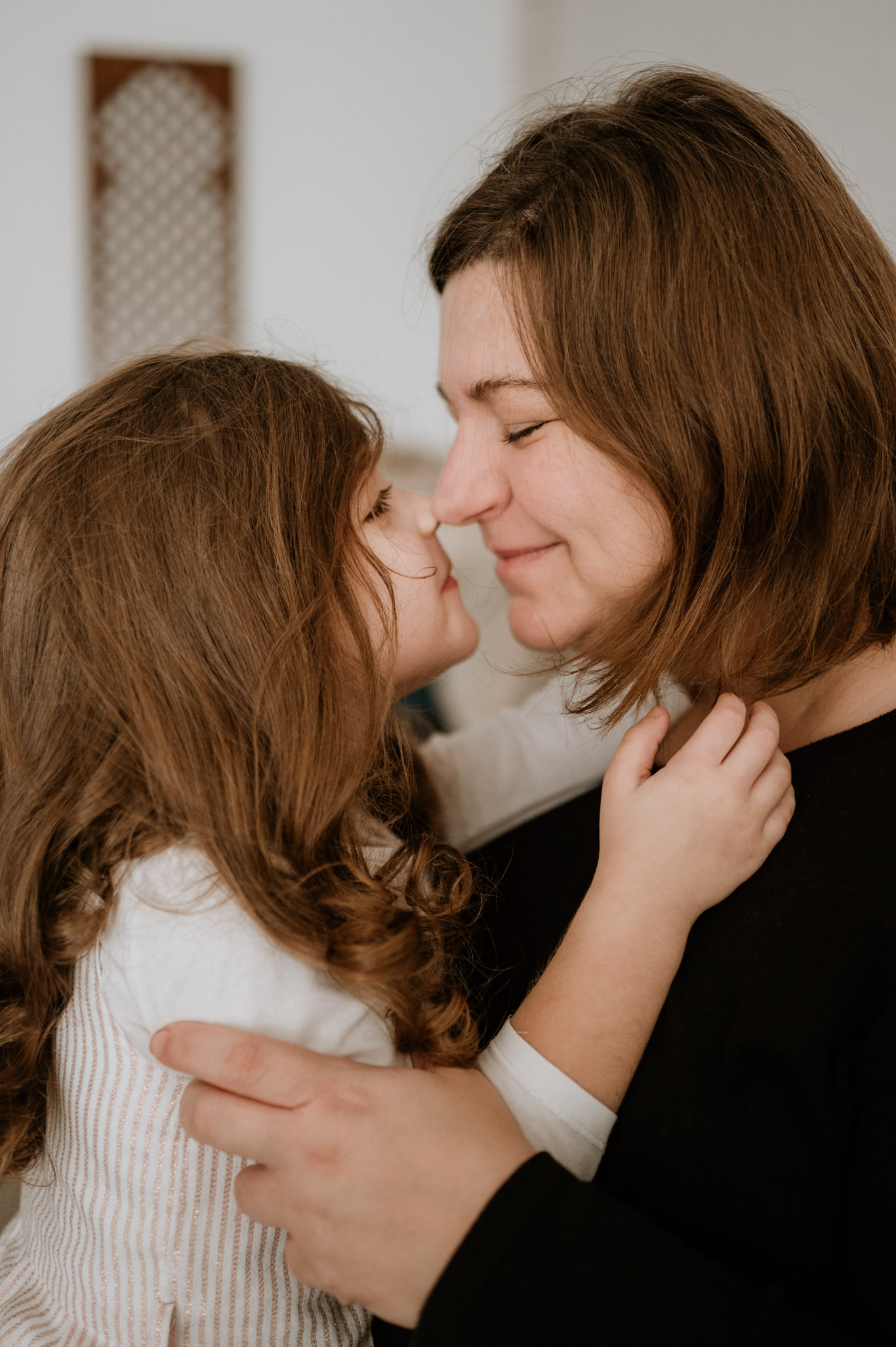 Mutter und Tochter kuscheln Nase an Nase miteinander