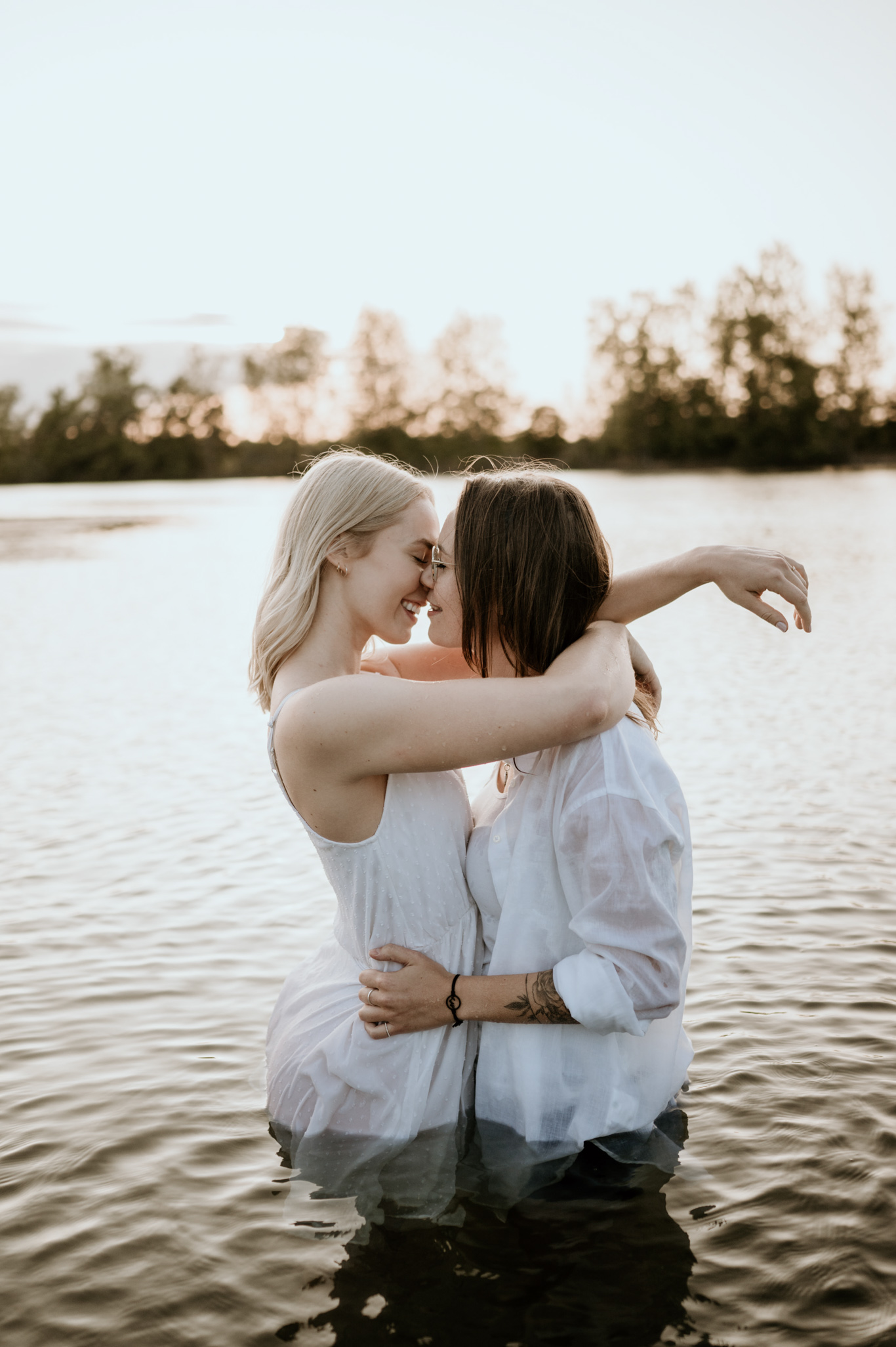Zwei Frauen stehen lachend im seichten Wasser des Sees