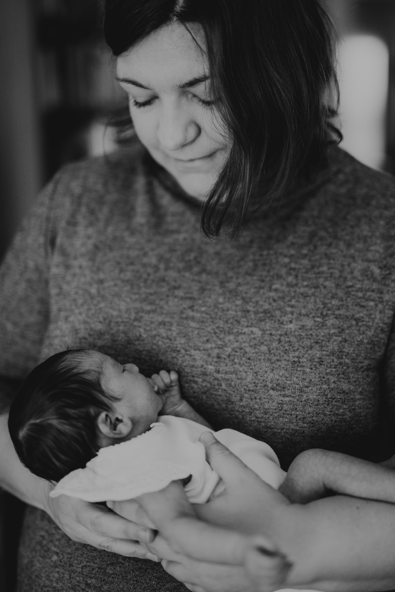 Schwarzweißaufnahme, Mutter hält ihr eingewickeltes Baby im Arm