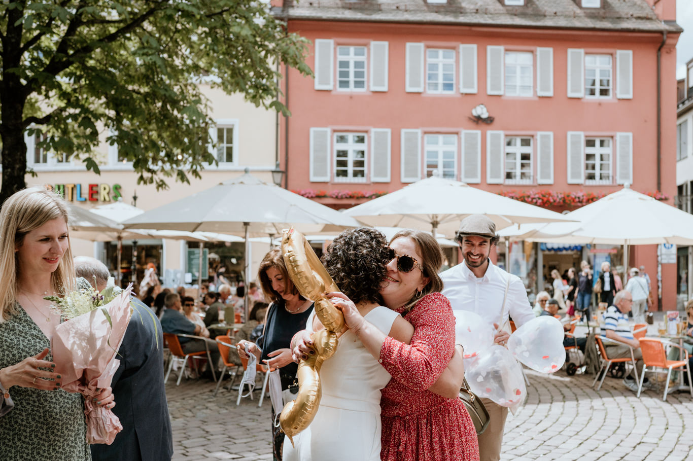 Gäste feiern mit goldenem Luftballon vor der Altstadt