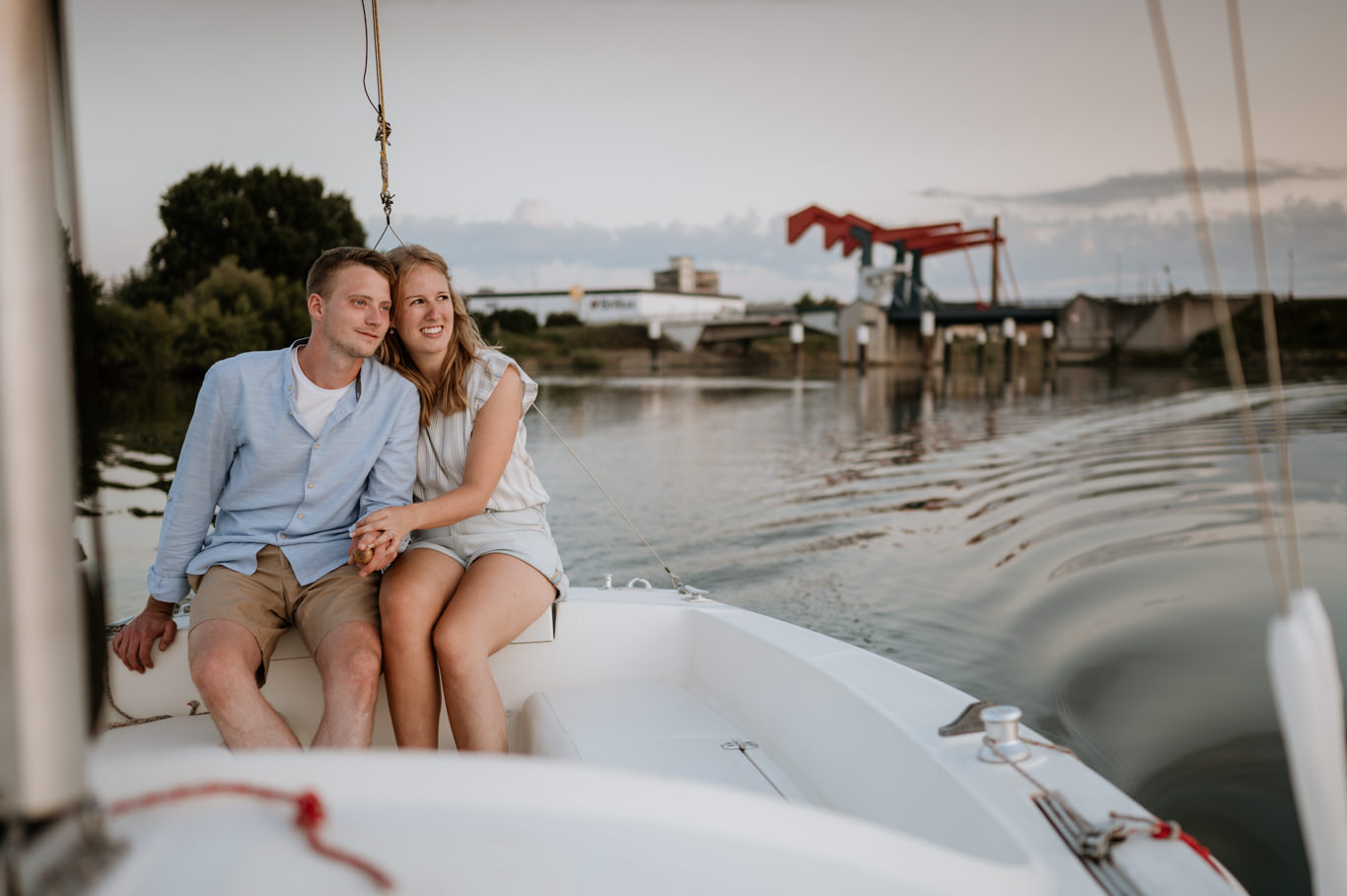 Paar sitzt eng nebeneinander im Boot bei Sonnenuntergang