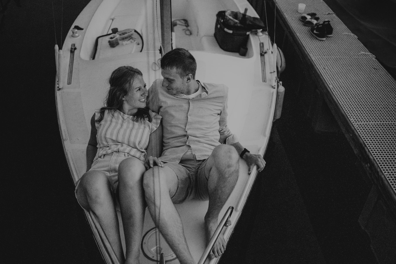 Paar sitzt eng umarmt im Cockpit des Segelboots, Schwarzweißaufnahme