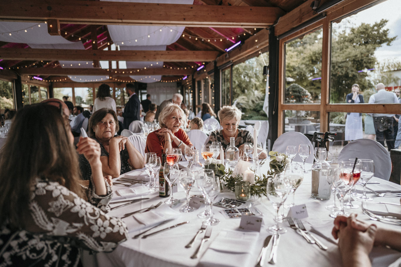 Hochzeitsgesellschaft sitzt festlich gedeckt an der Tafel im Zelt