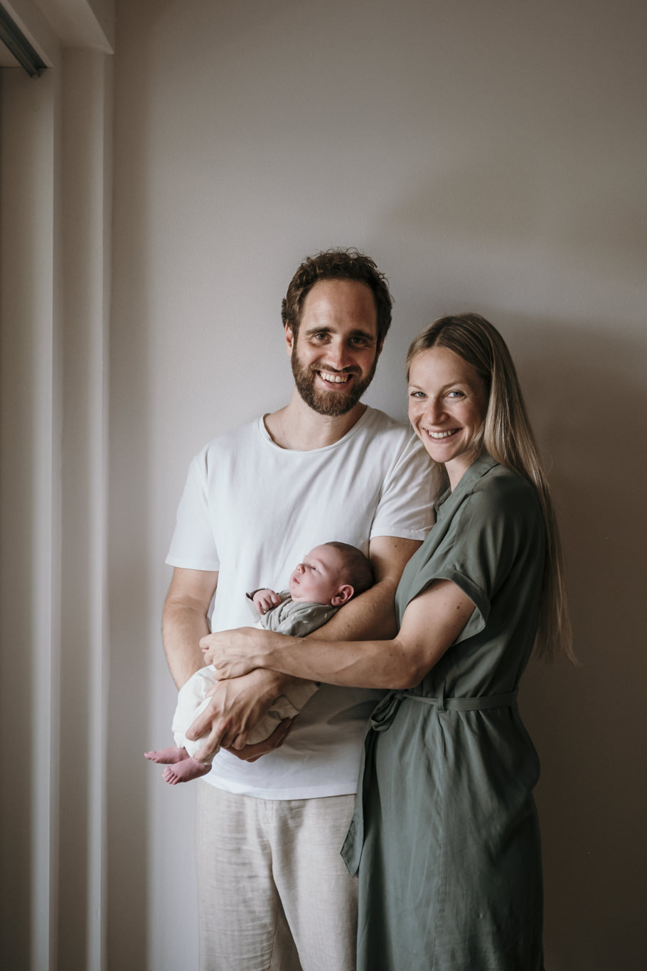 Eltern lächeln in die Kamera und halten ihr Baby