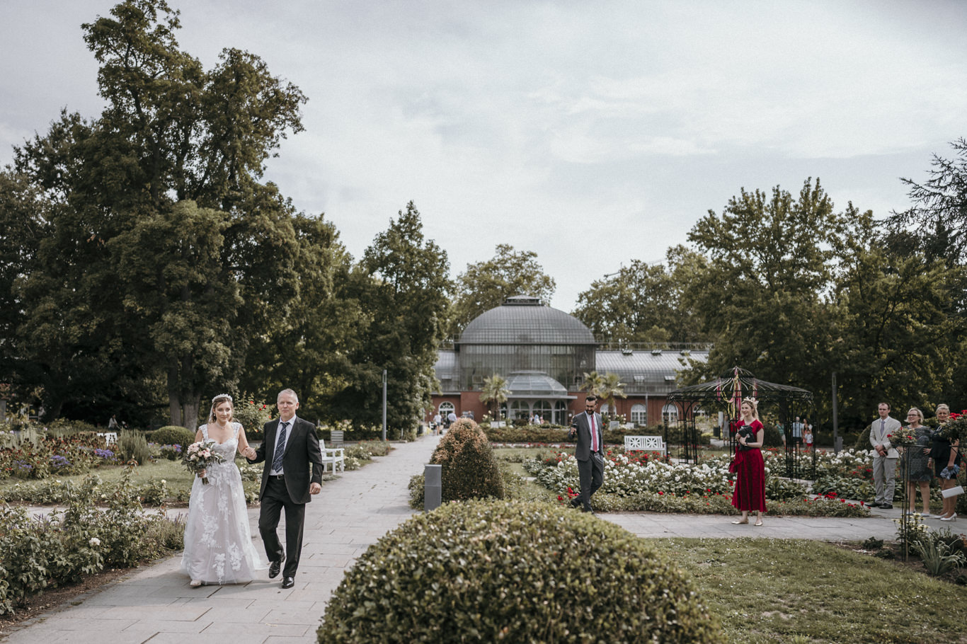 Gäste warten vor dem Gewächshaus im Park, Weitwinkelansicht