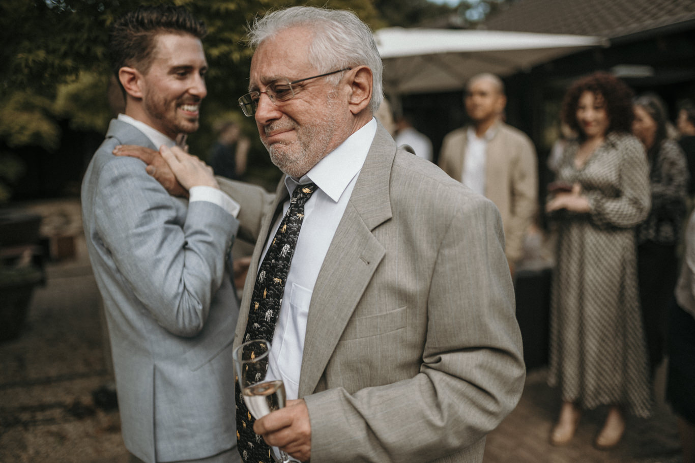 Älterer Gast gratuliert einem Bräutigam mit Handschlag
