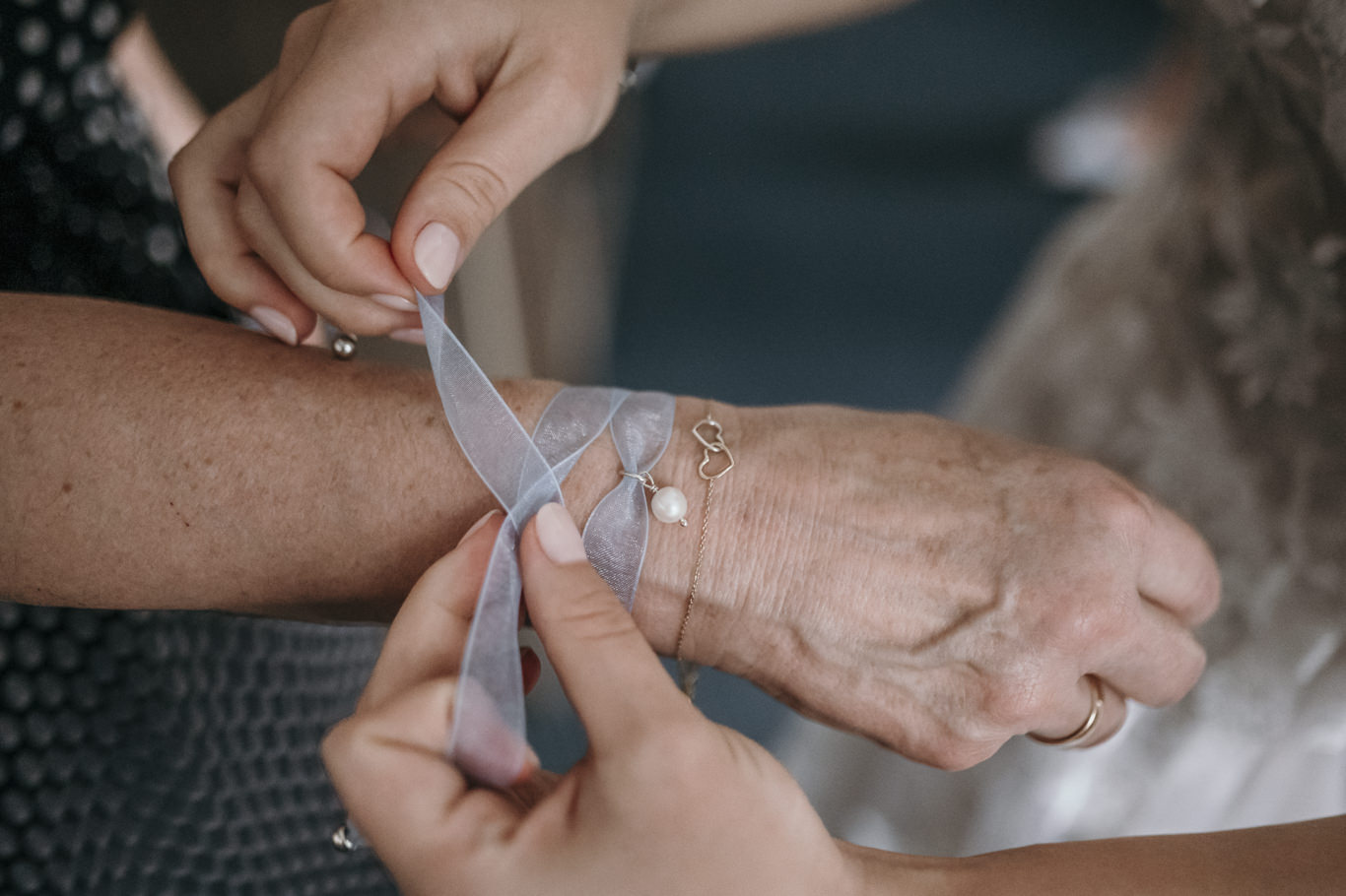 Ältere Frau bindet der Braut ein Armband ums Handgelenk, Schwarzweißaufnahme