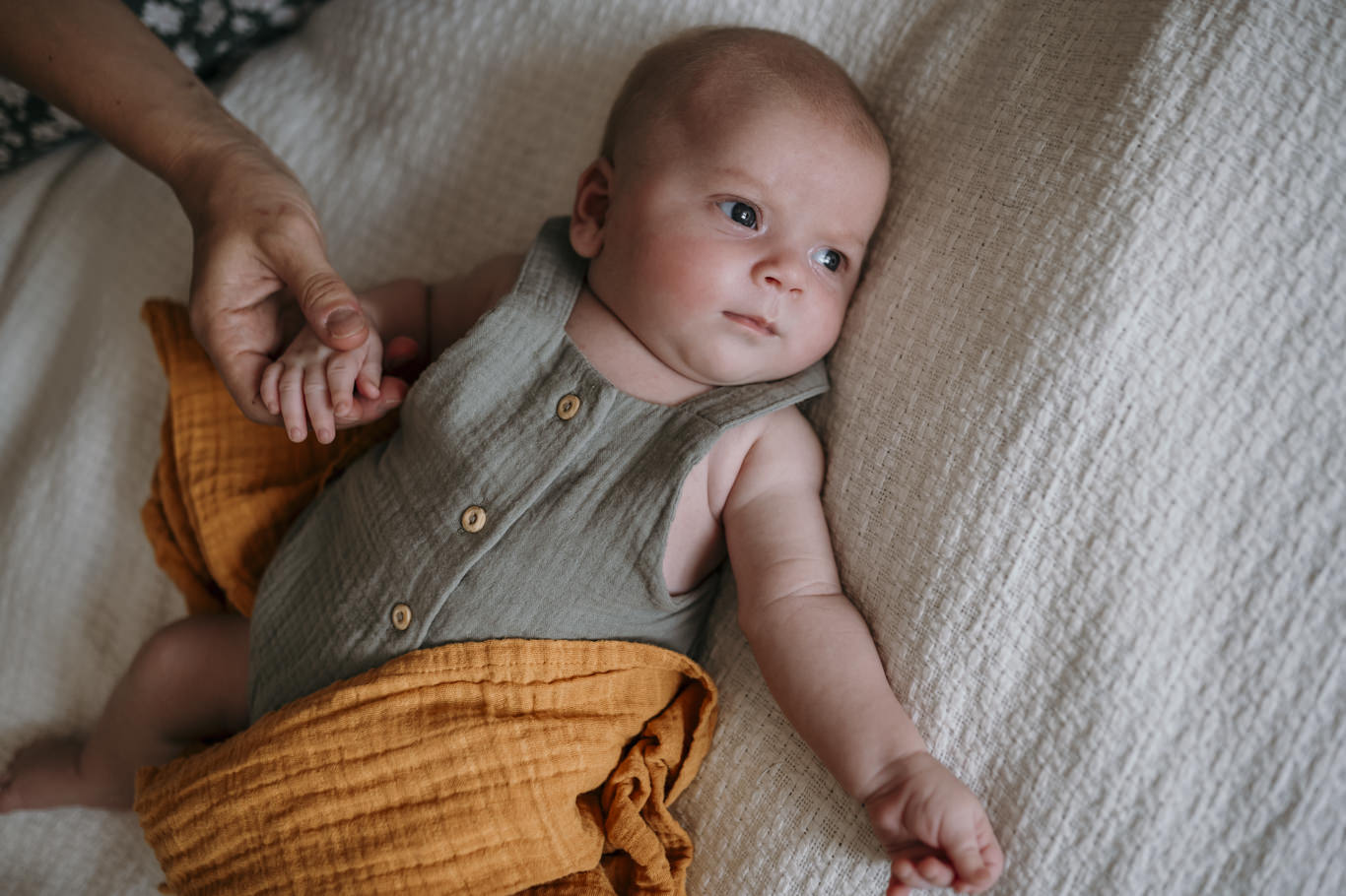 Vater hält die Hand seines Babys auf der Decke