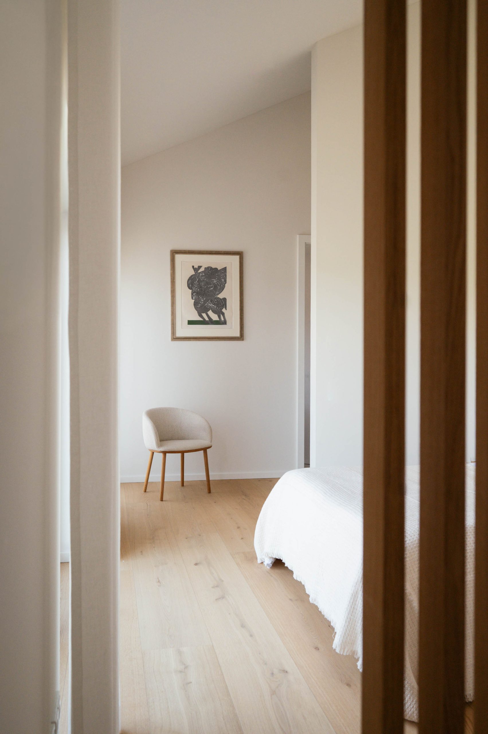 Blick durch Holzlamellen in ein helles Schlafzimmer