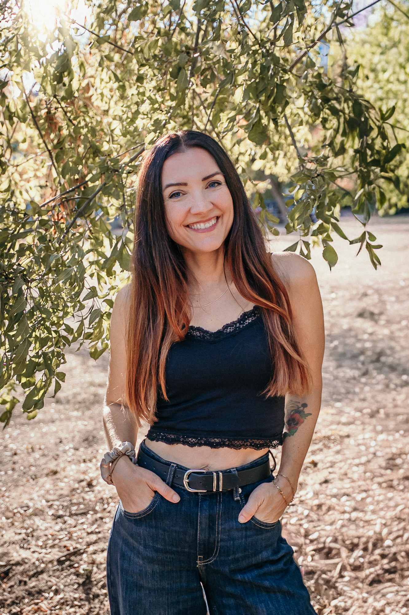 Simone Sohl, Hochzeitsfotografin, Familienfotografin, Newborn-Fotografin und Business-Fotografin, steht lachend vor einem Baum