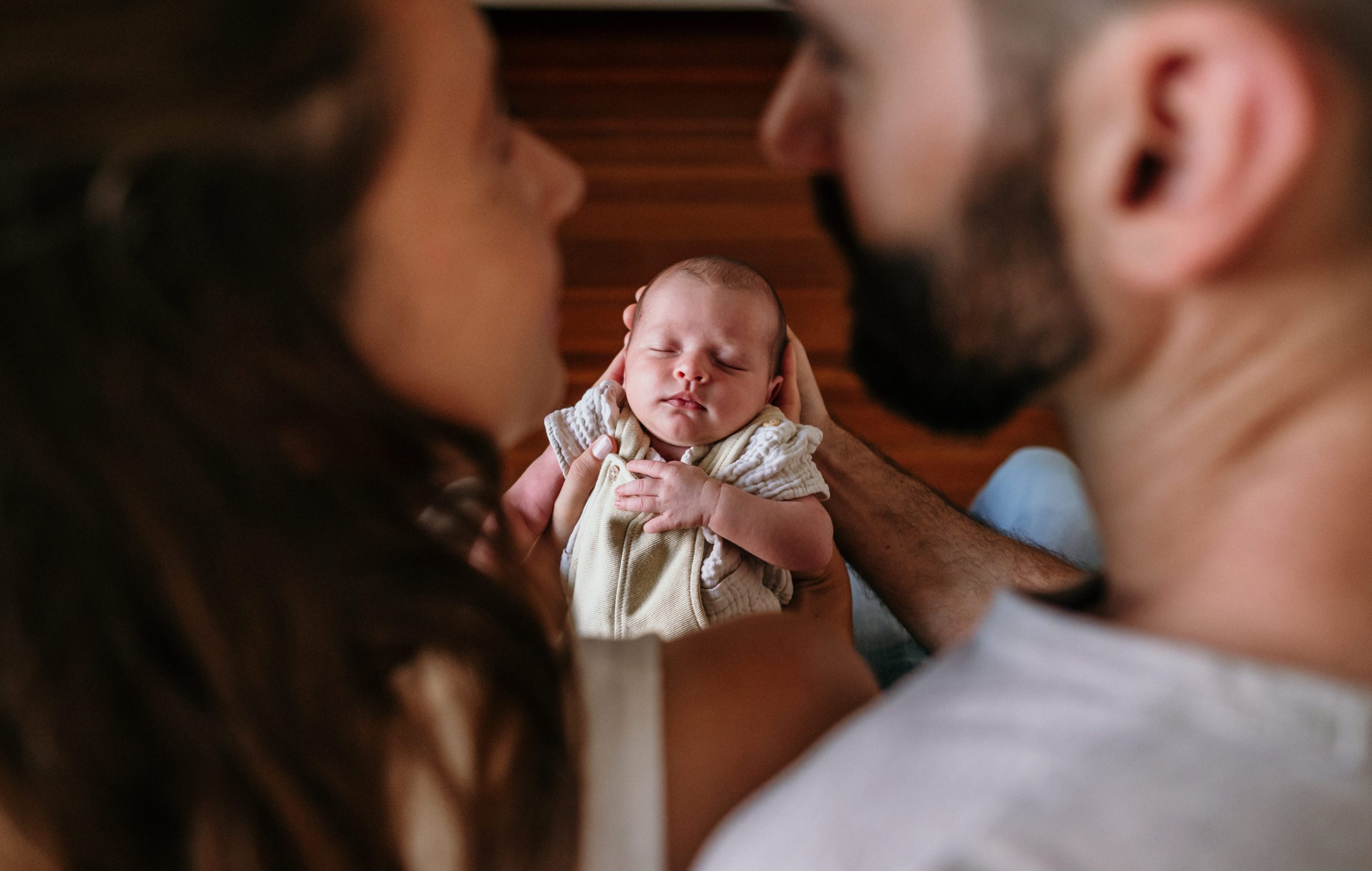 Eltern betrachten liebevoll ihr neugeborenes Baby auf dem Arm