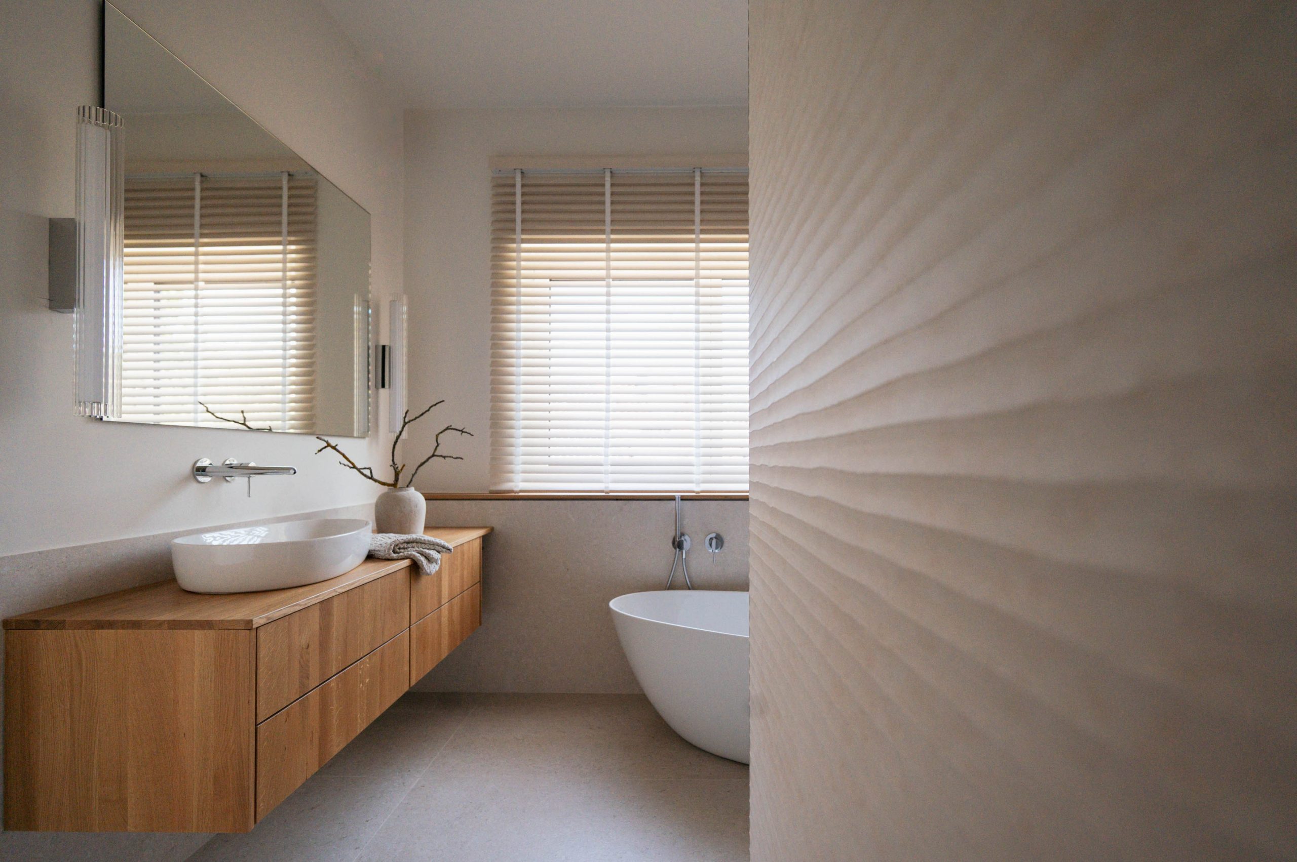 Modernes Badezimmer mit freistehender Wanne und strukturierter Wand