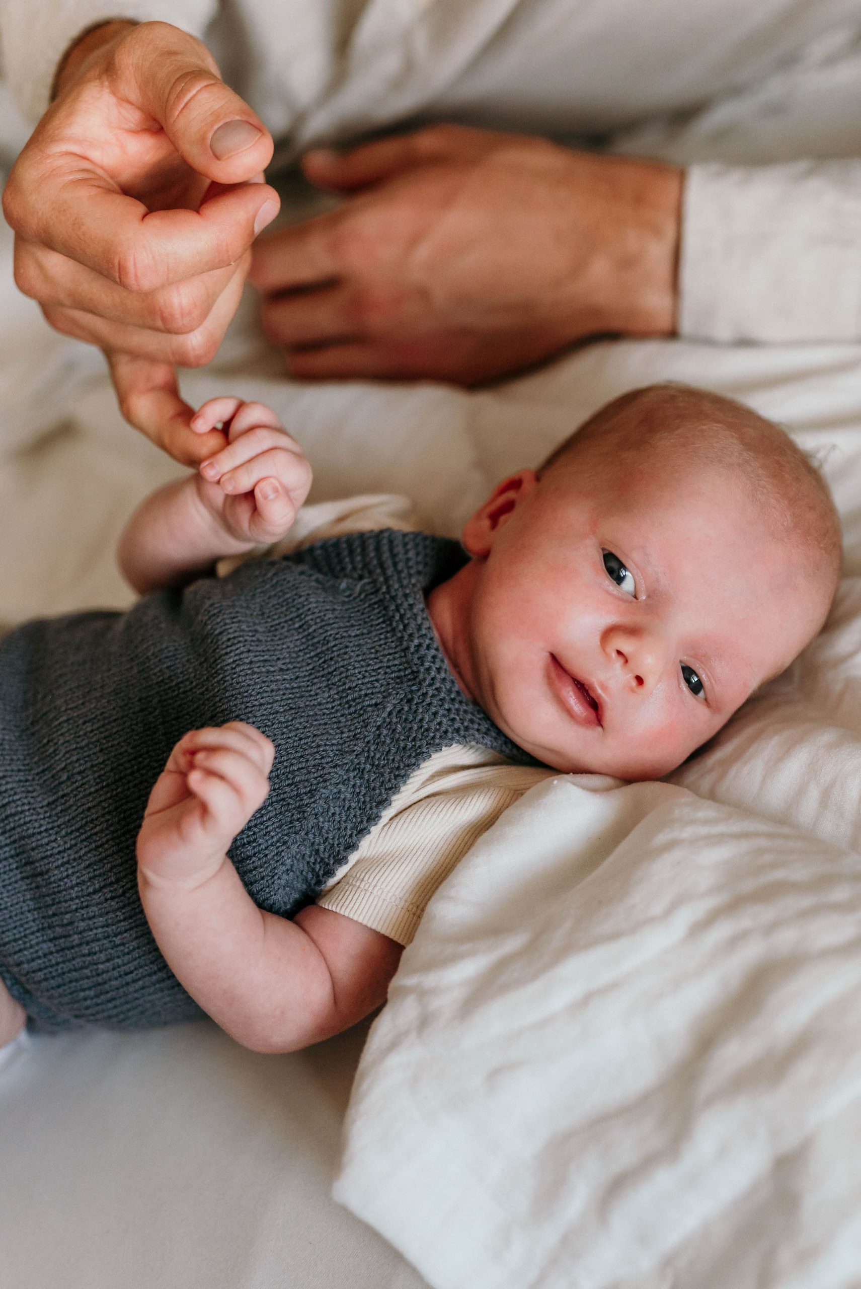 Neugeborenes liegt auf einem Bett bei Newborn Homestory