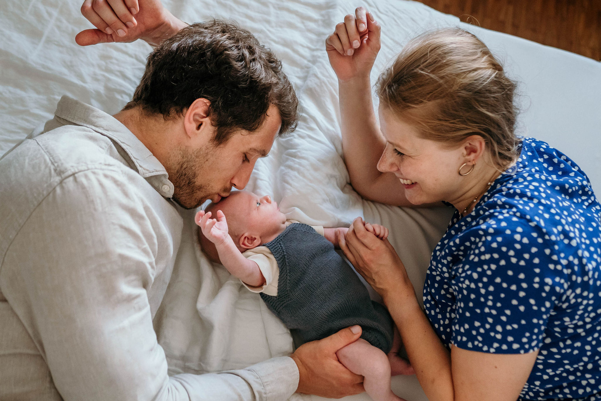 Vater küsst sein schlafendes Baby zärtlich auf die Stirn