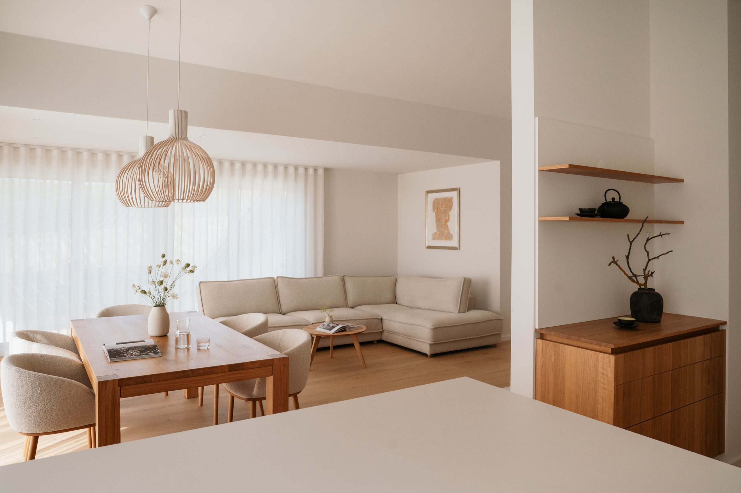 Wohnzimmer mit Sofa, Esstisch und Hängeleuchten im Naturlicht