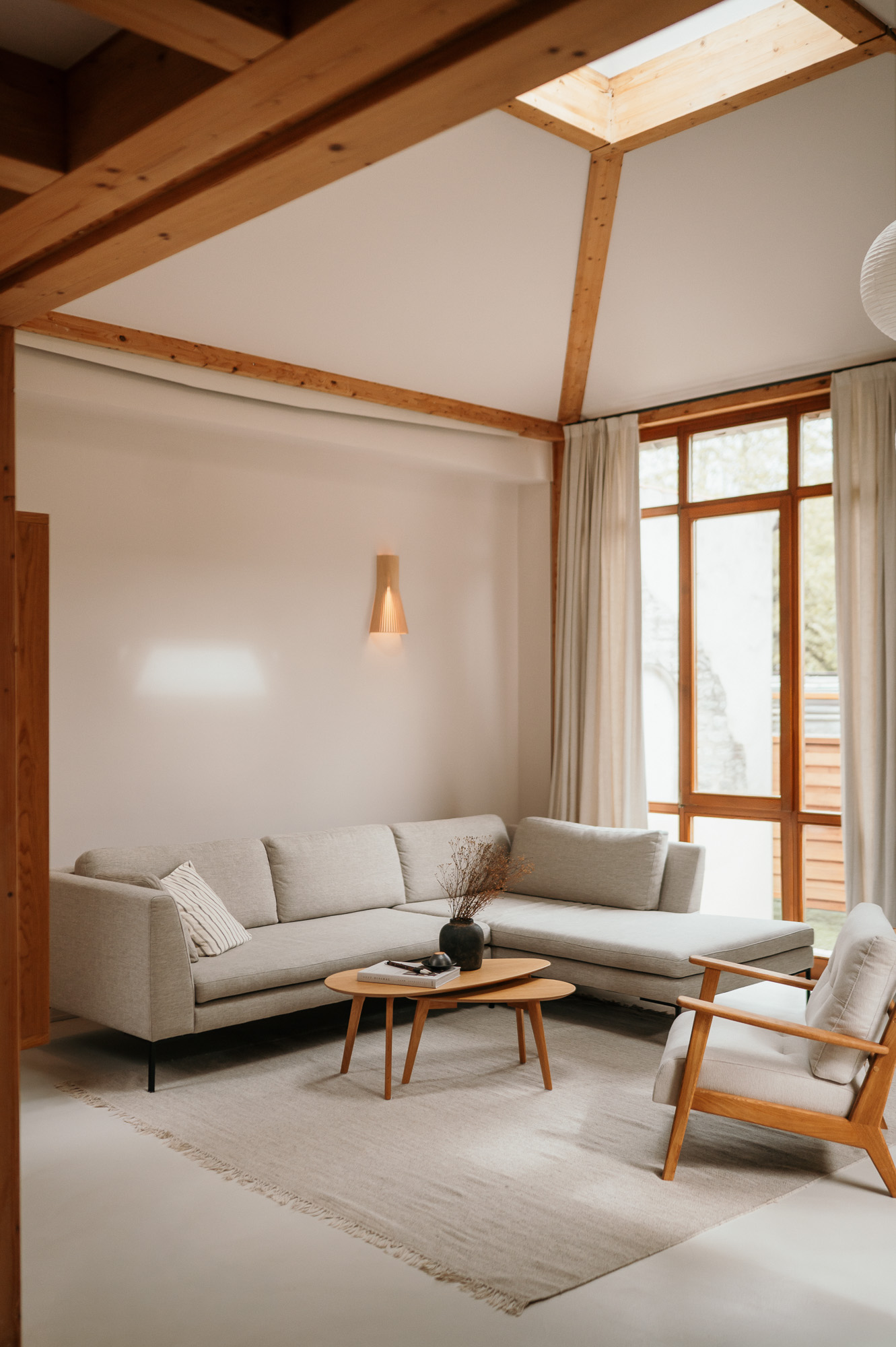 Wohnzimmer mit Holzbalkendecke, Dachfenster und Sofa