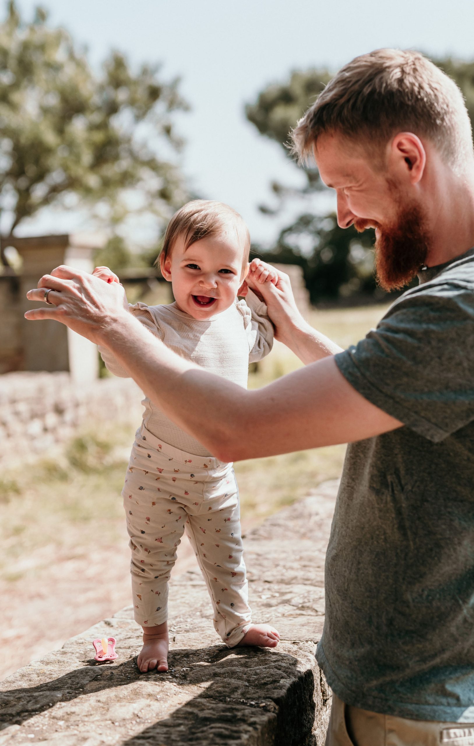 Einjähriges Kind bei Familienshooting in Bad Dürkheim im Sonnenschein an der Hand seines Papas
