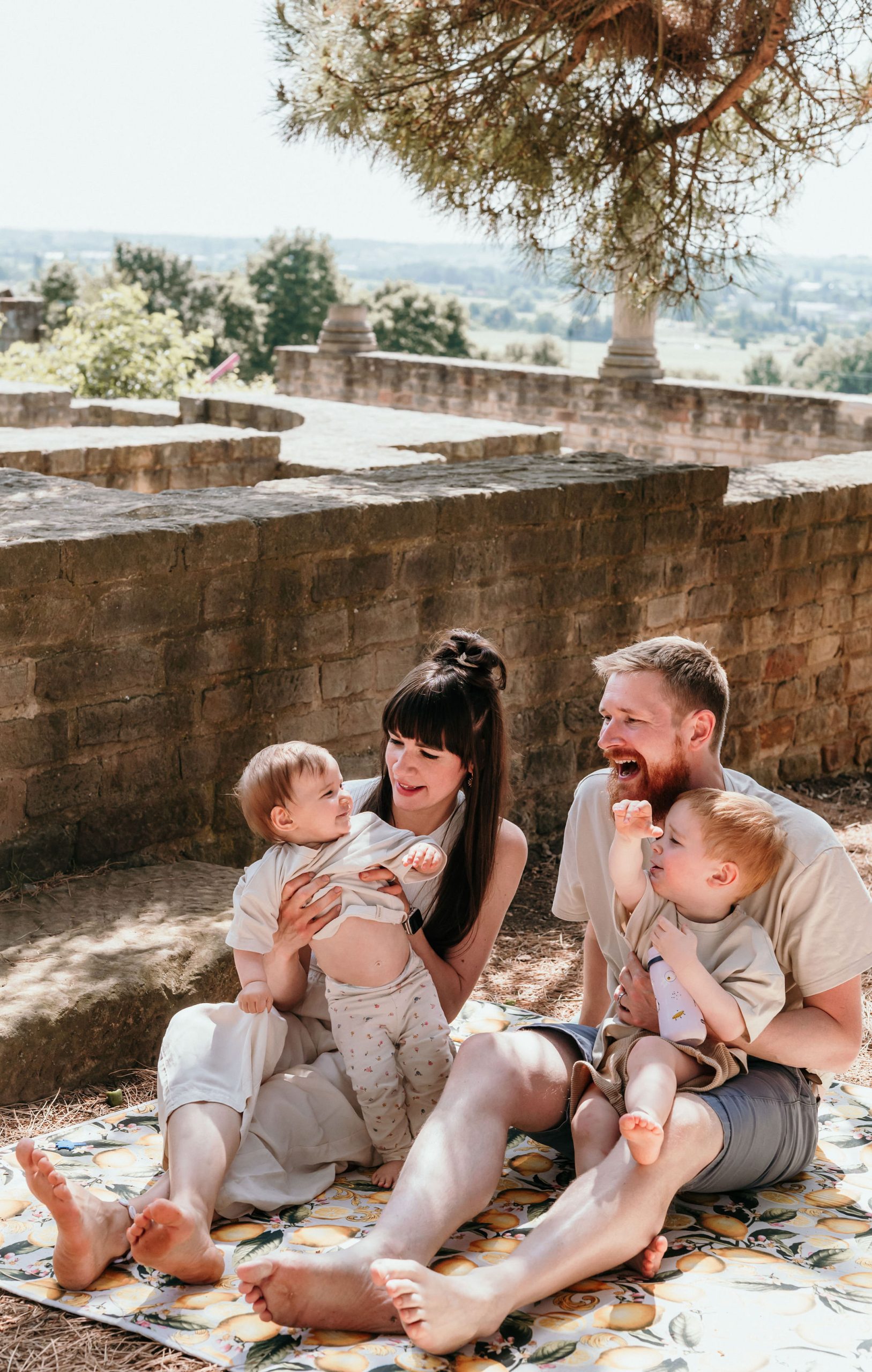 Familie glücklich lachend bei Familienfotografie in Bad Dürkheim im Sonnenschein vor Sandsteinmauern